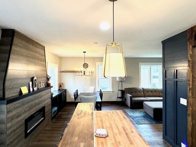 dining area with dark hardwood / wood-style floors and an inviting chandelier