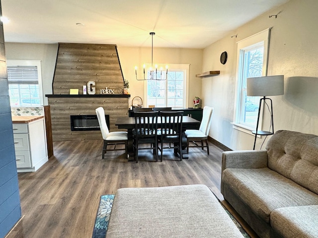 dining room featuring a fireplace, dark hardwood / wood-style flooring, and a chandelier