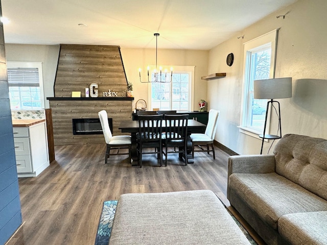 820 Labree Ave N, Thief River Falls, MN 56701 - dining space featuring a chandelier, healthy amount of natural light, wood finished floors, and a glass covered fireplace