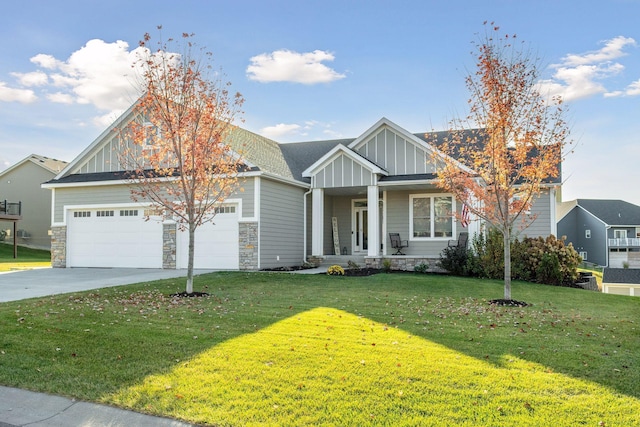 craftsman-style house featuring driveway, stone siding, covered porch, board and batten siding, and a front yard