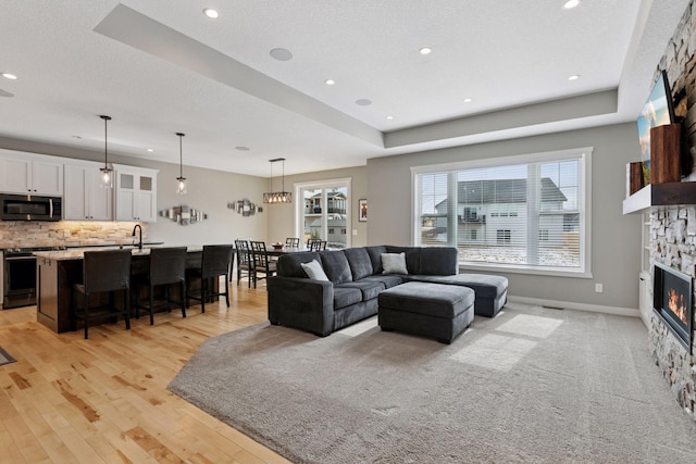 12770 196th Ave NW, Elk River, MN 55330 - living room with a fireplace, recessed lighting, light wood-style floors, baseboards, and a textured ceiling