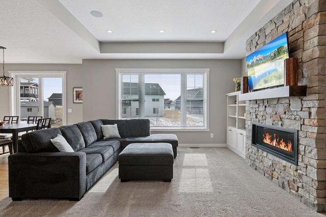 12770 196th Ave NW, Elk River, MN 55330 - carpeted living area featuring plenty of natural light, a fireplace, baseboards, a tray ceiling, and recessed lighting