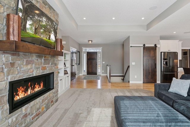 12770 196th Ave NW, Elk River, MN 55330 - living room featuring a barn door, a fireplace, light wood finished floors, baseboards, and recessed lighting