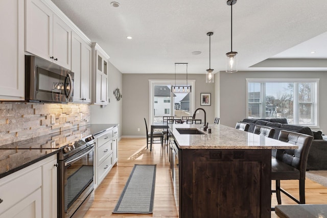 12770 196th Ave NW, Elk River, MN 55330 - kitchen with stainless steel appliances, a sink, light wood-style flooring, backsplash, and recessed lighting