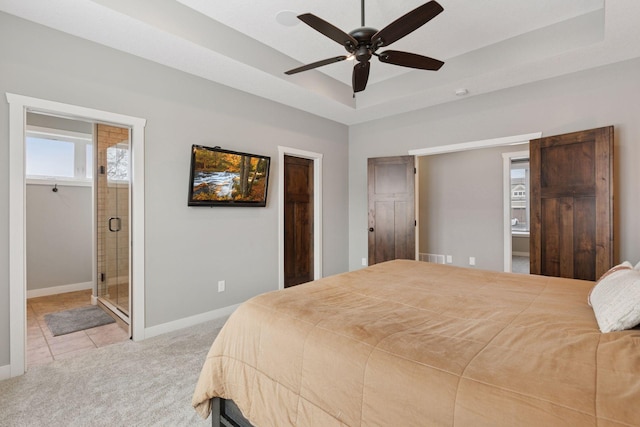 12770 196th Ave NW, Elk River, MN 55330 - carpeted bedroom featuring a raised ceiling, ensuite bathroom, baseboards, tile patterned floors, and a ceiling fan