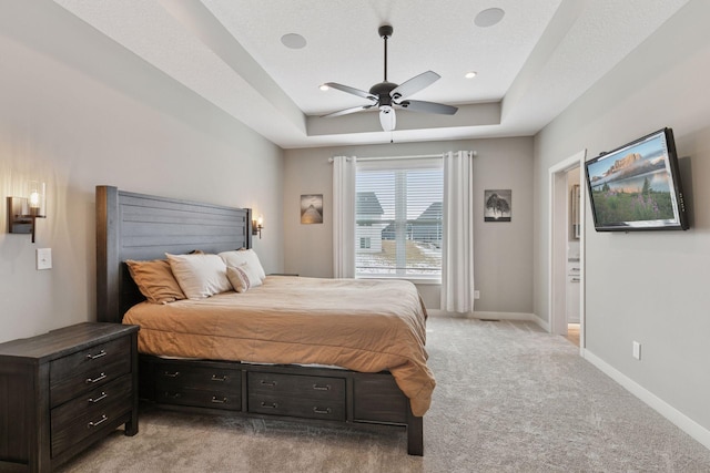 12770 196th Ave NW, Elk River, MN 55330 - bedroom featuring light carpet, a tray ceiling, baseboards, and a ceiling fan