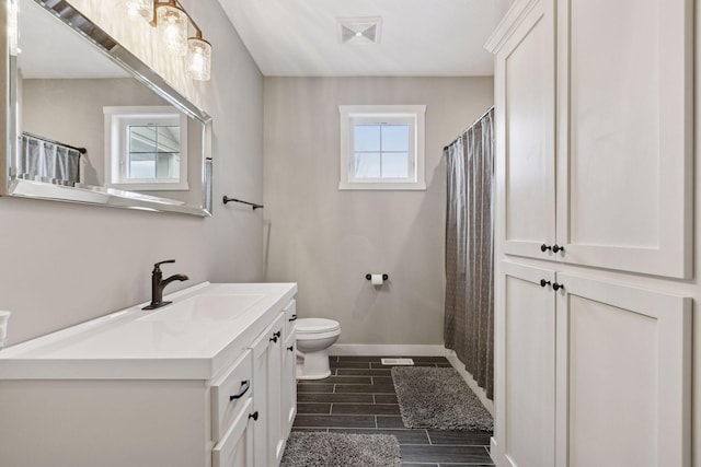 12770 196th Ave NW, Elk River, MN 55330 - full bathroom featuring toilet, wood finish floors, baseboards, vanity, and a shower with shower curtain