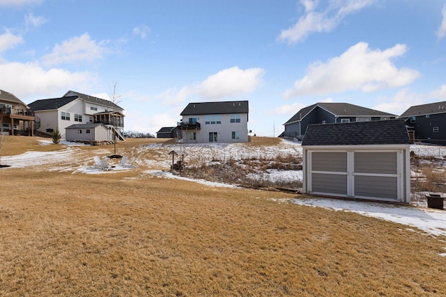12770 196th Ave NW, Elk River, MN 55330 - yard layered in snow featuring a shed, a garage, an outdoor structure, and a residential view