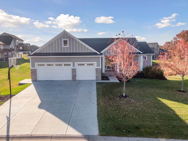 12770 196th Ave NW, Elk River, MN 55330 - view of front of house with stone siding, driveway, a front lawn, and board and batten siding