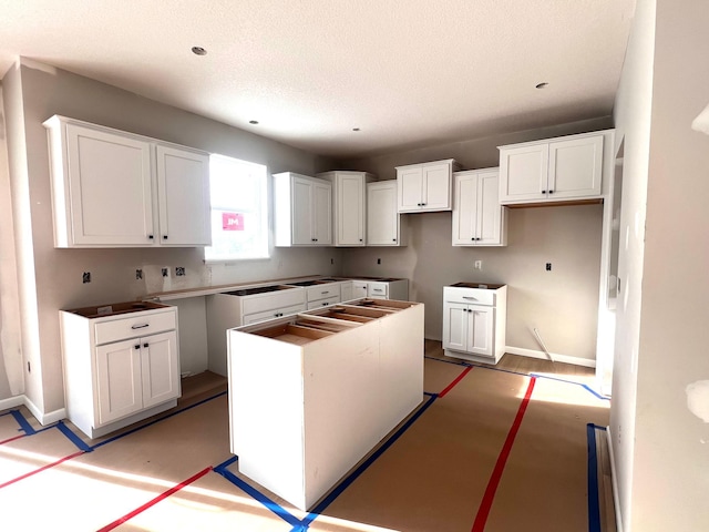 kitchen featuring white cabinetry, a textured ceiling, and a kitchen island