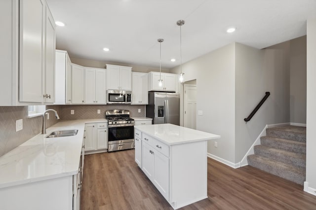 kitchen featuring pendant lighting, a center island, sink, white cabinetry, and stainless steel appliances