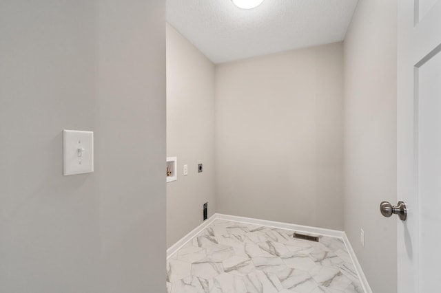 washroom with a textured ceiling, hookup for a washing machine, and hookup for an electric dryer