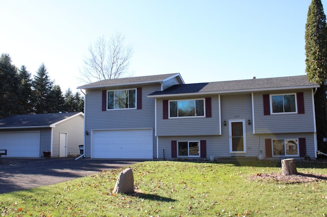 bi-level home with a garage and a front lawn