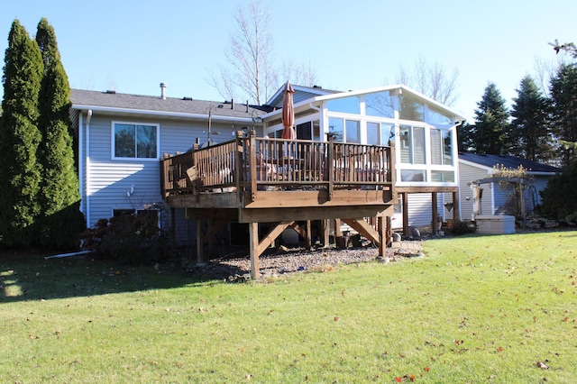 back of property with a yard, a sunroom, and a wooden deck