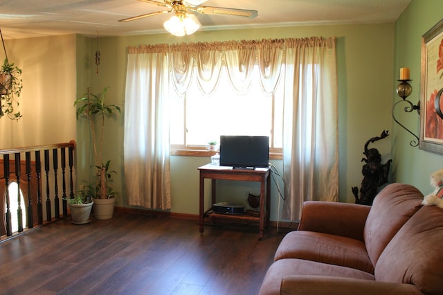 sitting room with dark wood-style flooring and ceiling fan