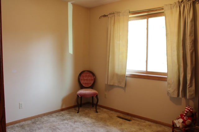 interior space featuring light colored carpet, visible vents, and baseboards