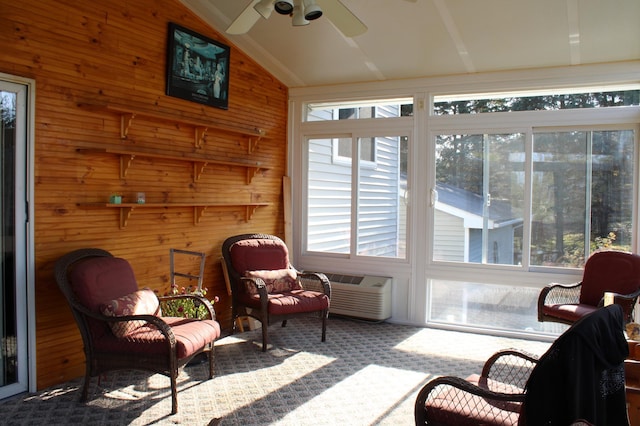 sunroom / solarium featuring lofted ceiling, a wall unit AC, and ceiling fan