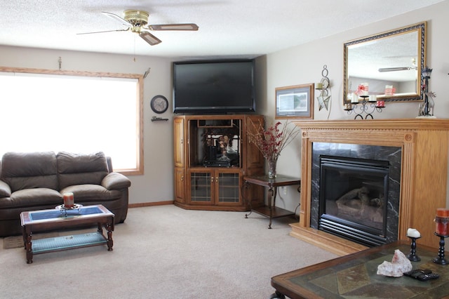 living area featuring carpet, a fireplace, a ceiling fan, a textured ceiling, and baseboards