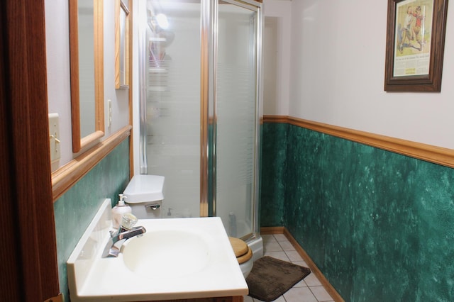 bathroom with tile patterned flooring, a shower stall, and vanity