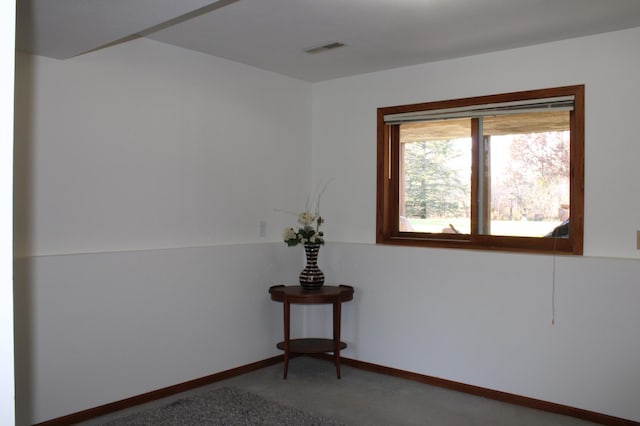 unfurnished room with baseboards, visible vents, and carpet flooring