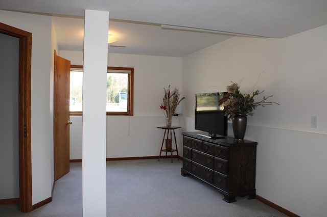 interior space featuring baseboards and light colored carpet