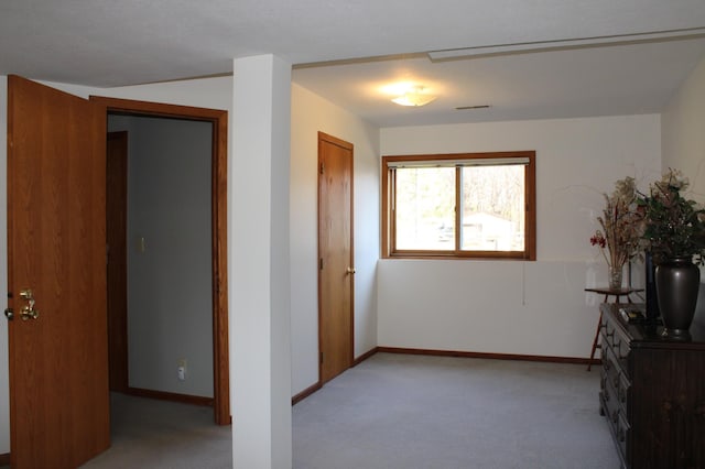 interior space featuring light carpet, visible vents, and baseboards