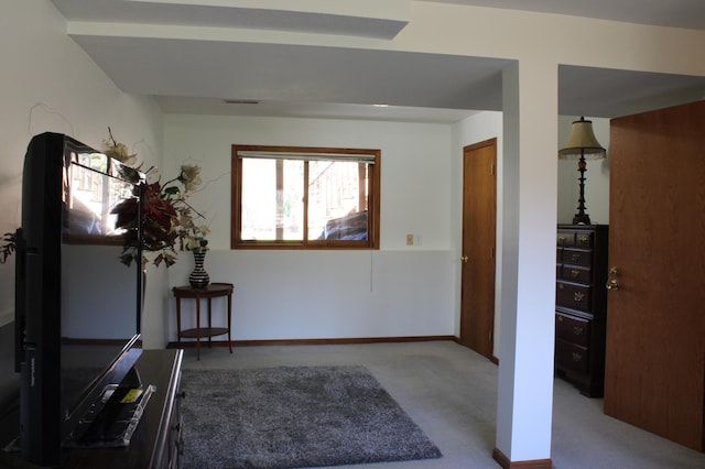 interior space featuring baseboards and light colored carpet