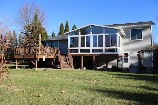 back of house featuring a sunroom, stairs, a deck, and a yard