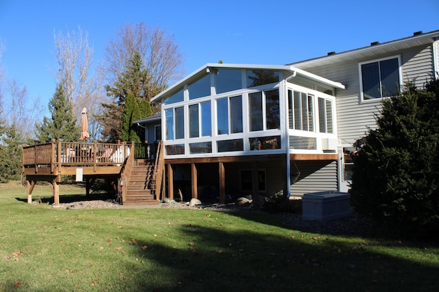 back of property with a deck, a lawn, stairs, and a sunroom