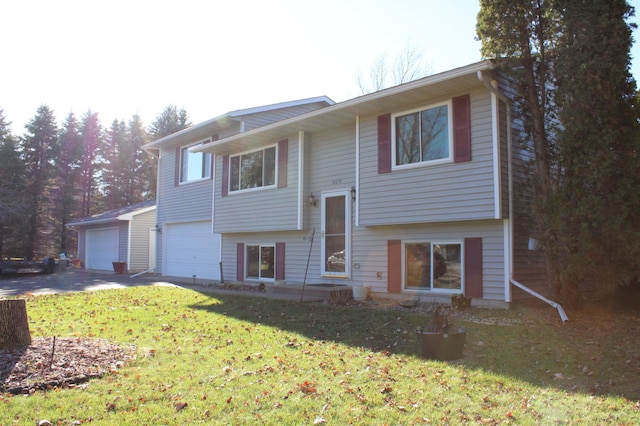 raised ranch featuring concrete driveway and a front yard