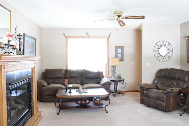 living area with a glass covered fireplace, light carpet, ceiling fan, and baseboards