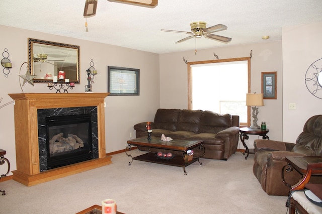 living area featuring light carpet, ceiling fan, a textured ceiling, and a fireplace