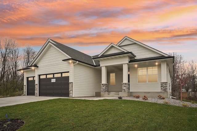 craftsman-style home with a yard, covered porch, and a garage