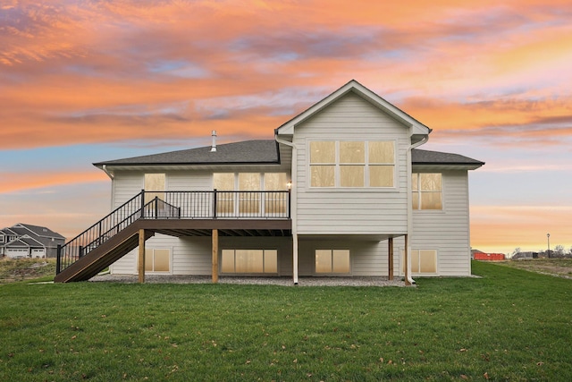 back house at dusk with a yard and a wooden deck