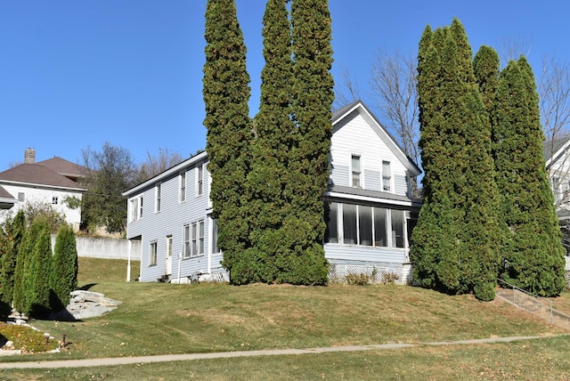 view of home's exterior featuring a yard and a sunroom