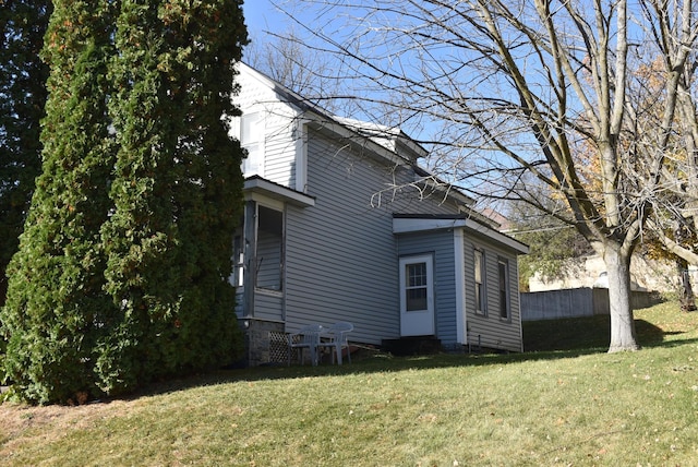 view of side of home with a yard