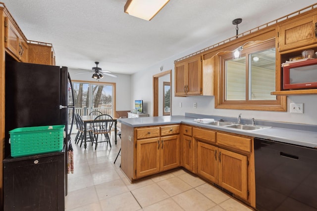 kitchen featuring ceiling fan, pendant lighting, black appliances, kitchen peninsula, and a textured ceiling