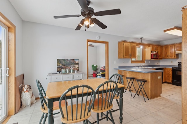 dining room featuring ceiling fan, sink, and light tile patterned flooring