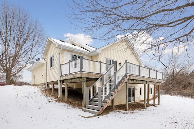 snow covered rear of property featuring a wooden deck