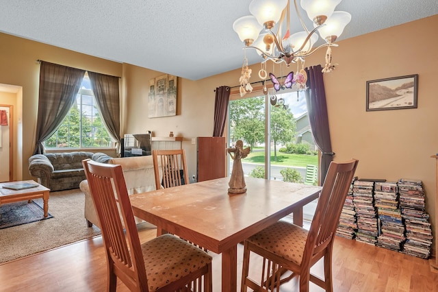 dining space with a chandelier, a textured ceiling, and light hardwood / wood-style flooring