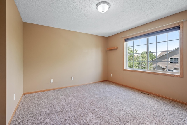 unfurnished room featuring carpet and a textured ceiling