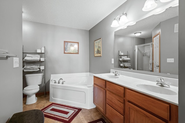 full bathroom featuring toilet, vanity, a textured ceiling, and tile patterned floors