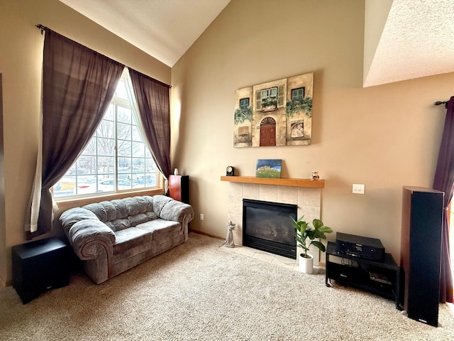 sitting room featuring high vaulted ceiling, carpet flooring, and a tile fireplace