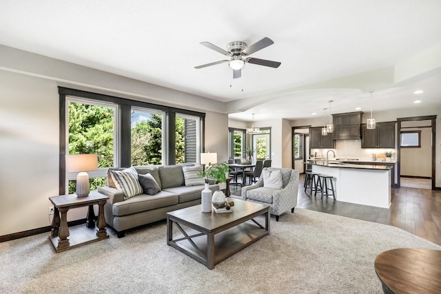 living room with dark hardwood / wood-style floors, ceiling fan, sink, and a wealth of natural light