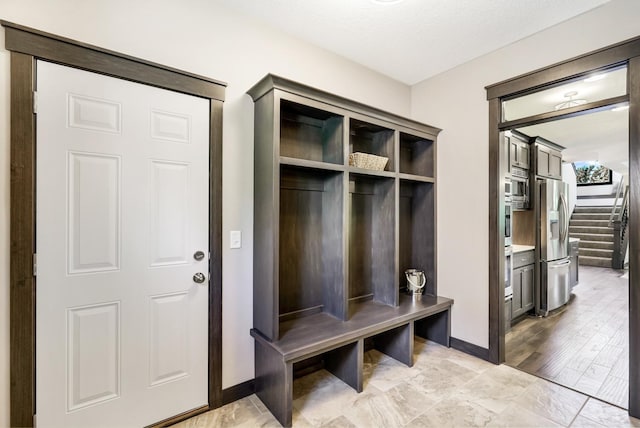 mudroom with a textured ceiling and light wood-type flooring