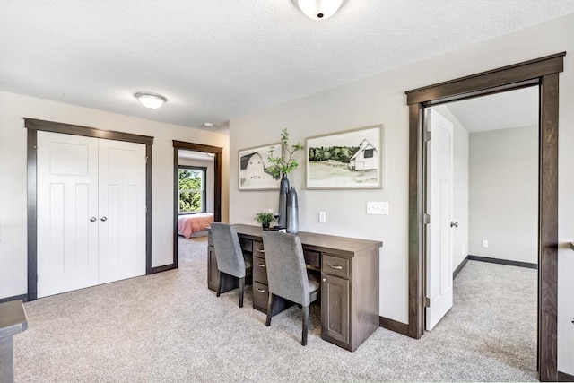 carpeted office featuring a textured ceiling