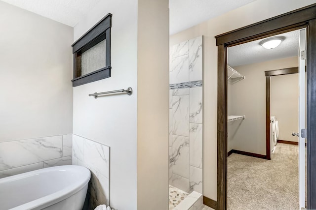 bathroom with washer / dryer, a textured ceiling, tile walls, and independent shower and bath