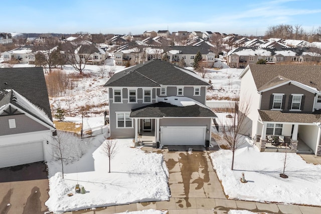 view of front of property featuring a residential view, concrete driveway, and a garage