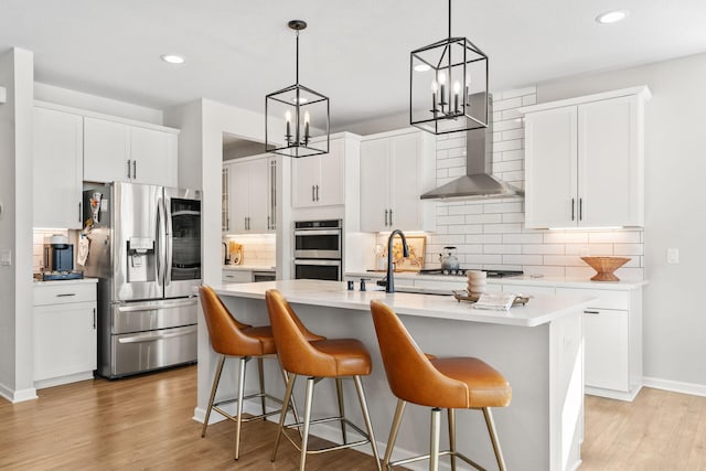 kitchen with a notable chandelier, light wood-style flooring, stainless steel appliances, and light countertops