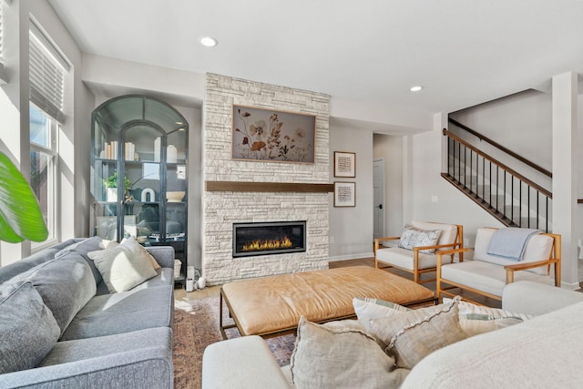 living area featuring stairs, recessed lighting, wood finished floors, and a fireplace